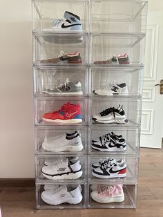 a large stack of clear shoes on top of a wooden floor