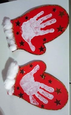 two handprinted red mittens with white hands and stars on them, sitting next to each other