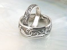 two wedding rings sitting on top of each other