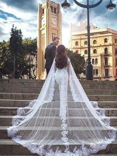 a bride and groom standing on some steps