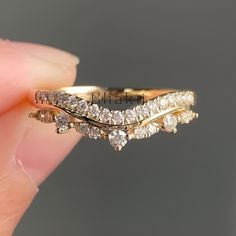 a person holding a gold ring with three diamonds on it's sides and the other side