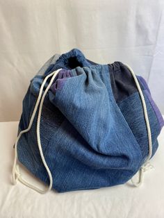 a blue denim bag with white drawstrings on the front and back sides