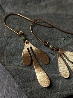 Brushed brass leaves on elegant elongated brass ear wires, with a little pop of color from a patterned turquoise Czech glass bead in the middle. Details: Total length: ~5.5cm Brass ear wires  glass bead size: ~3.5mm Find more Silver and Moss earrings here:  https://www.etsy.com/shop/silverandmoss?section_id=32748105 + Please note that all jewelry is handmade and may vary slightly <3  The best efforts have been made to take photos representing the true colors of the item, however colours may vary Handmade Bronze Brass Teardrop Earrings, Bohemian Bronze Jewelry With French Hook, Bohemian Brass Leaf Jewelry, Bohemian Leaf-shaped Brass Jewelry, Gold Leaf-shaped Copper Jewelry, Handmade Adjustable Brass Teardrop Earrings, Turquoise Teardrop Brass Jewelry, Unique Gold Teardrop Earrings Nickel Free, Bohemian Gold Leaf Jewelry