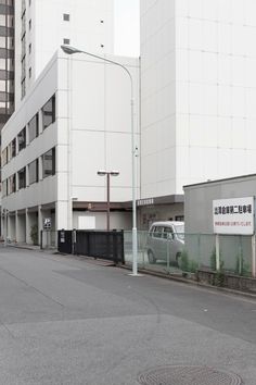 an empty street in front of a large white building with chinese writing on the side