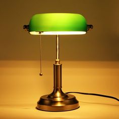 a green table lamp sitting on top of a counter