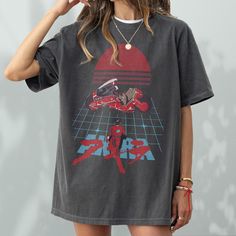 This vintage Akira inspired Anime t-shirt is perfect gift for anime fans and fans of 80s japanese films, this Akira graphic tee shirt pays homage to the iconic manga and animated masterpiece. This anime streetwear neo-tokyo akira shirt features a vintage-inspired graphic and pays homage to the dystopian world of Neo-Tokyo and the unforgettable characters, Kaneda and Tetsuo. The custom Akira-inspired t-shirt is a unisex fit for men and women and is also available in children's sizes (please messa 90s Anime Print Crew Neck T-shirt, Retro Anime Print Tops For Streetwear, 90s Anime Print Crew Neck Top, Retro Black Anime Print Tops, 90s Anime Print Short Sleeve T-shirt, Black Retro Anime Print Top, Black Retro Top With Anime Print, Retro Black Top With Anime Print, Retro Anime Print Tops For Fan Merchandise