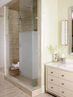 a bathroom with a walk in shower sitting next to a sink and a large mirror