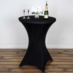 a black table with champagne and flowers on it