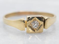 a yellow gold ring with a diamond in the center