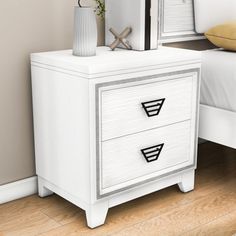 a white nightstand with two drawers and a mirror on top of it next to a bed