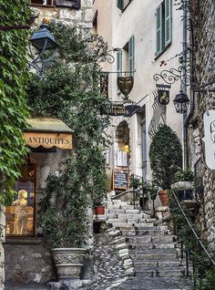 an alleyway with stone steps leading up and down to the shops on both sides