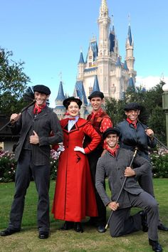 a group of people standing in front of a castle at disney world posing for a photo