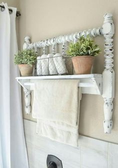 a white shelf with some plants and towels on it