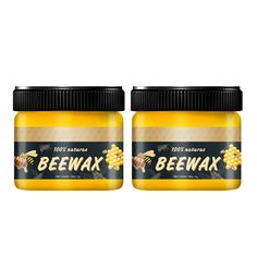 two jars of beewax honey sitting next to each other