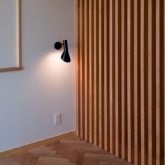 the light is on in the corner of the room next to the wood paneled wall