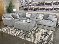 a large sectional couch with matching footstools in a living room setting at a furniture store