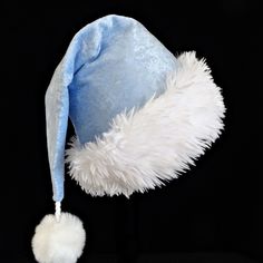 Pastel blue is the color of this panne velvet Santa hat.  It is fully lined with cotton fabric and there is a soft and fluffy white faux fur trim turn up band accent.  The hat styled in the classic slouch Santa stocking hat, generously sized to fit teen and adult head sizes.  Measurement of the hat band is 24-25" circumference and the length of the hat is 20". There is a snowy white faux fur pompom dangle on the hat. Christmas Hats, Christmas Holiday Party, Stocking Hat, Santa Stocking, Saint Nicolas, Bleu Pastel, Saint Nicholas, White Faux Fur, Costume Hats