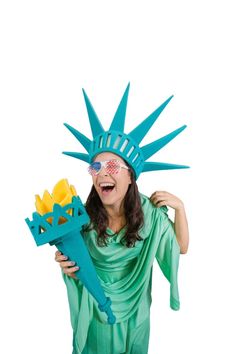 a woman dressed as the statue of liberty holding a bouquet of flowers in her hands