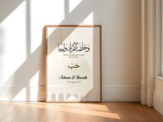 an islamic wedding program is displayed in a frame on the floor next to a window