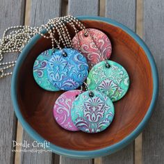 several pictures of different types of buttons in a bowl with chains and rubber stamps on them