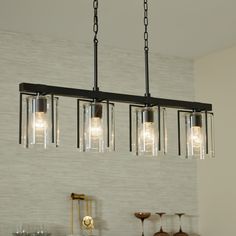 a chandelier with five lights hanging from it's sides in a kitchen