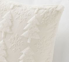 a white pillow with snowflakes on it and a christmas tree in the middle