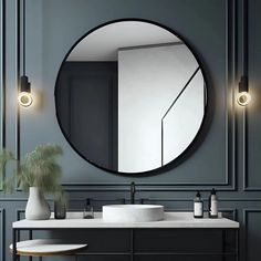 a bathroom with a large round mirror above the sink and two vases on the counter