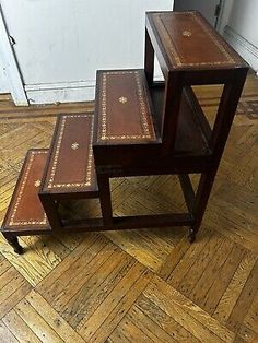 three wooden nesting tables with leather seats on the bottom and one sitting on the floor