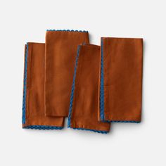 three pieces of brown cloth with blue trims