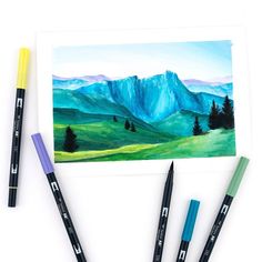 three watercolor pencils sitting on top of a piece of paper