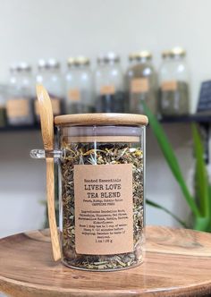 a jar filled with herbs and a wooden spoon