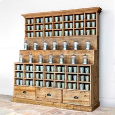 an old wooden shelf with many jars on it