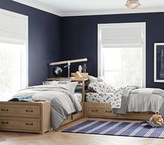 a child's bedroom with blue walls and wooden furniture, including two twin beds