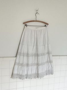 an early 1900s petticoat made from white cotton and hand crocheted panels and trim. double layered.  features a pin in back closure. in  good vintage condition with no rips or  tears. some spots on back. see last pictures for closeup.  please note waist measurement are flexible because of cinched waist  waist:28' length 31' Vintage Cotton Tiered Petticoat, Vintage Cotton Petticoat For Daywear, Vintage Lace Trim Petticoat For Summer, Victorian White Cotton Petticoat, White Cotton Petticoat With Lace Trim, Vintage Lace Petticoat For Summer, Vintage White Lace Petticoat, Waist Measurement, Early 1900s