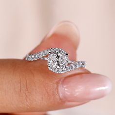 a woman's hand holding a diamond ring