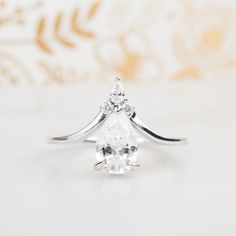 a white gold ring with a pear shaped diamond