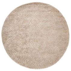 a round rug with an abstract design on the top and bottom, in beige tones