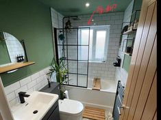 a bathroom with green walls and white fixtures