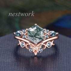 a ring with an emerald colored stone surrounded by blue topazte and diamond accents