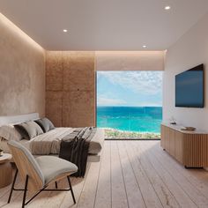 a bedroom with an ocean view is shown in this image, the room has white walls and wood flooring