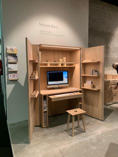 a desk with a computer on it in a display area at a museum or exhibition