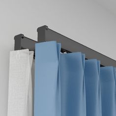 blue and white curtains are hanging on the side of a curtain rod with black hardware