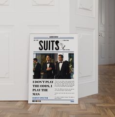 an advertisement for suits on the wall next to a door in a room with wooden floors