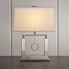 a silver table lamp with a white shade on the base and a square shaped light