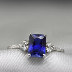 An impressive radiant cut Sapphire brings rich color to this ring, contrasted by brilliant diamond side stones set in a shimmering 10,14 or 18 Karat gold setting.- Made to Order, Perfectly finished, Fast shipping fully insured and trackable online.- Gemstone info: Sapphire corundum 8x6 mm, Excellent cut, 1.54 ct- Diamond info: 16 x Diamonds ranging from 1-1.75mm, VS-E, 0.15 ctw- Arrives gift ready with a certificate of authenticity Timeless Radiant Cut Cubic Zirconia Diamond Ring, Cubic Zirconia Diamond Ring With Center Stone, Square Cut, Classic Formal Diamond Ring With Lab-created Sapphire, Diamond White Square Cut Promise Ring, Rectangular Brilliant Cut Sapphire Ring For Formal Occasions, Square Cut Cubic Zirconia Diamond Ring With Center Stone, Elegant Square Cut Moissanite Rings, Fine Jewelry Diamond Ring Cubic Zirconia Radiant Cut, Dazzling Square-cut Diamond Promise Ring