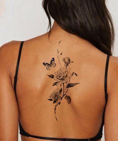 a woman's back tattoo with roses and butterflies