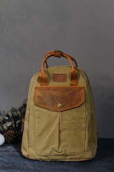 Waxed canvas backpack with genuine leather details. Waterproof width: 34cm ( 13,38 inch) height: 40 cm ( 15,74 inch) Depth: 10cm ( 3,93 inch) This stylish canvas leather bag fits perfectly into any style. Made from high quality canvas, this bag stands out with its durability and long-lasting use. Thanks to its large internal volume, it allows you to carry your daily belongings in an orderly manner. Moreover, it adds elegance to the design with its leather details. Whether you carry it on your shoulder or hold it in your hand; This bag will offer you style and comfort. You will make a difference with its unique design, striking colors and quality materials. Add elegance to your wardrobe by purchasing this stylish canvas leather bag now! Waxed Canvas Backpack, Canvas Leather Tote Bag, Canvas Leather Tote, Canvas Leather Bag, Women's Backpack, Bag Stand, Crossbody Messenger Bag, Leather Gifts, Vintage Canvas