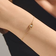 xEvoke an aura of protection and style with our Evil Eye Bracelet. This elegant and symbolic piece showcases the classic evil eye motif, believed to ward off negative energies and bring good fortune. Crafted in radiant gold, the delicate design is both fashionable and meaningful. Adorn your wrist with this timeless talisman to not only enhance your look but also invite positivity and ward off negativity. Elevate your jewelry collection with this enchanting and culturally significant bracelet. - Gold Evil Eye Bracelet, Baguette Earring, Eye Motif, Dot Ring, Baguette Ring, Gold Link Chain, Solid Gold Chains, Knot Ring, Delicate Design