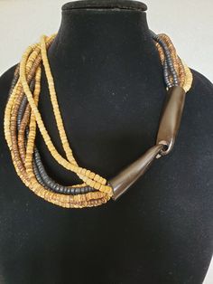 "This listing is for a vintage Dyed horn and coconut shell beaded necklace with 12 strands. Talk about organic! The necklace is made by the famous Denmark Jewelry designer Gerda Lynggaard now Monies. It is closed off with 2 dark chocolate dyed horns with hook clasp. It is in excellent condition and will arrive in a gift box with FREE SHIPPING. Measures: 24 1/2\"L  Material: dyed horns, coconut shell, blond stone beads, clear nylon cord Hallmark: Unsigned Gerda Lynggard-Monies, typical of her jew Artisan Multi-strand Brown Beads, Traditional Brown Multi-strand Necklaces, Artisan Brown Multi-strand Beaded Necklace, Shell Beads Necklace, Bone Horn, Hook Clasp, Coconut Shell, Jewelry Pins, Shell Beads