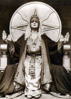 an old black and white photo of a woman sitting on a throne